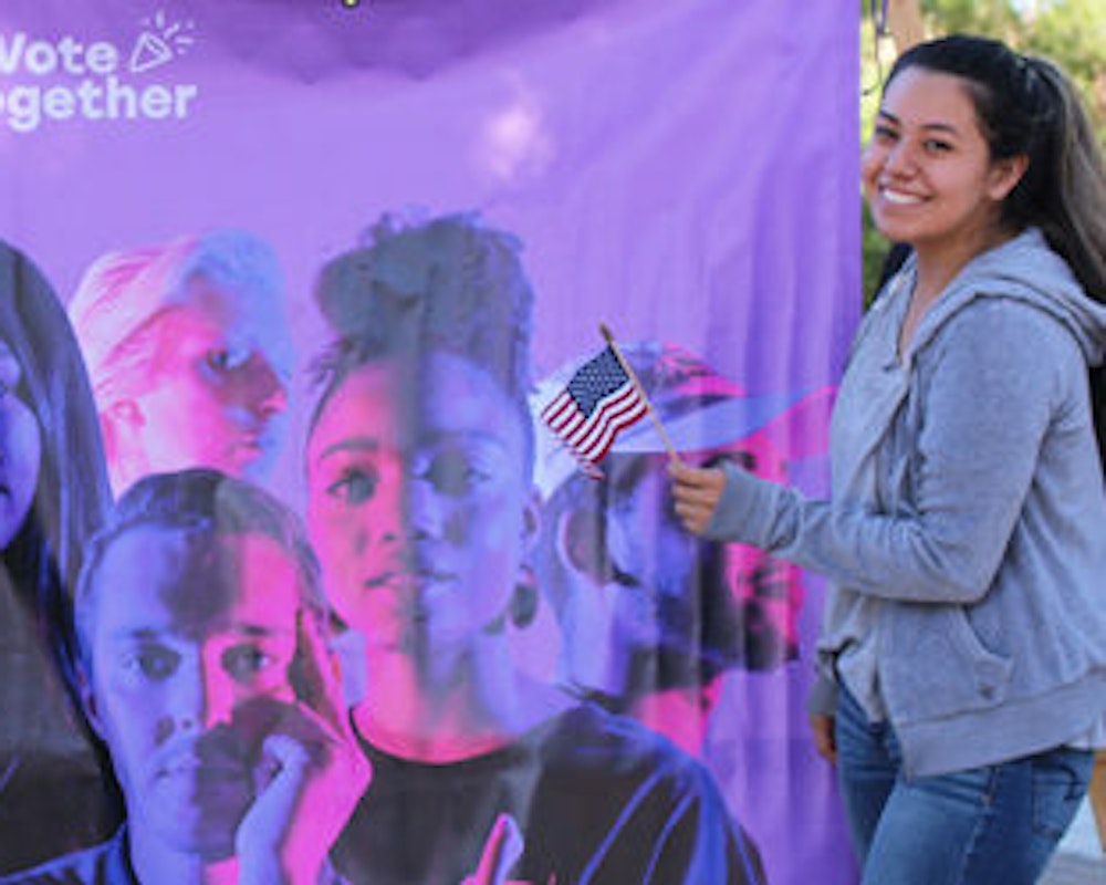 A student holding a flag at the College of the Canyons