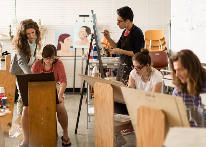 Adults and children painting together in an art studio